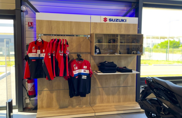 Vu d'ensemble d’une gondole merchandising Suzuki Moto avec barre de charge, tablettes de présentation et finitions personnalisées.